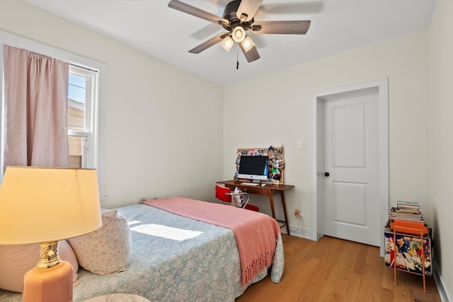 bedroom with baseboards, ceiling fan, and wood finished floors