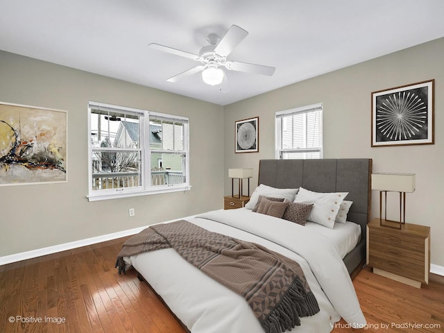 bedroom with baseboards, wood finished floors, and a ceiling fan