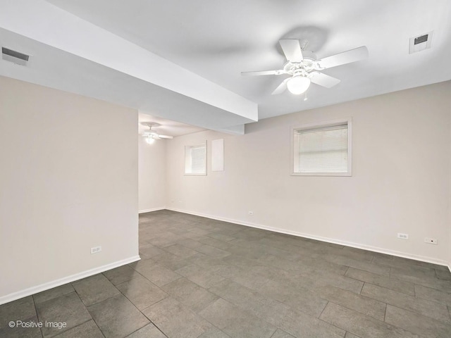 basement with visible vents, baseboards, and a ceiling fan