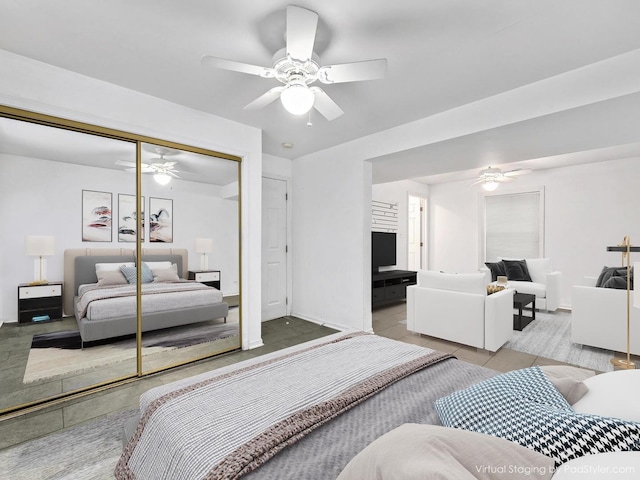 bedroom featuring a closet, tile patterned floors, baseboards, and ceiling fan