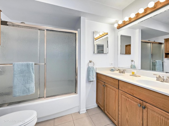 full bath with toilet, a sink, tile patterned flooring, double vanity, and enclosed tub / shower combo