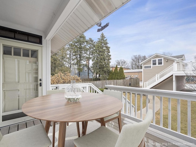 wooden terrace with outdoor dining space and fence