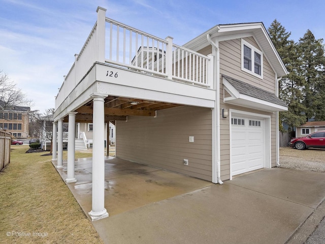 view of side of home featuring a carport, a yard, a garage, and driveway