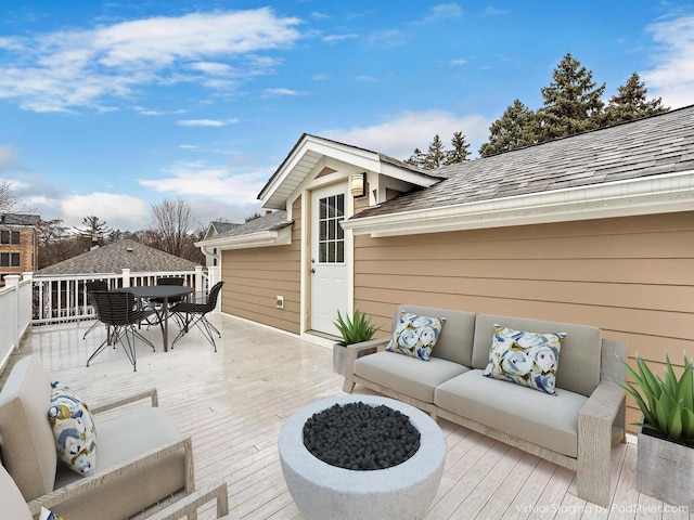 wooden deck with outdoor dining space and an outdoor living space with a fire pit