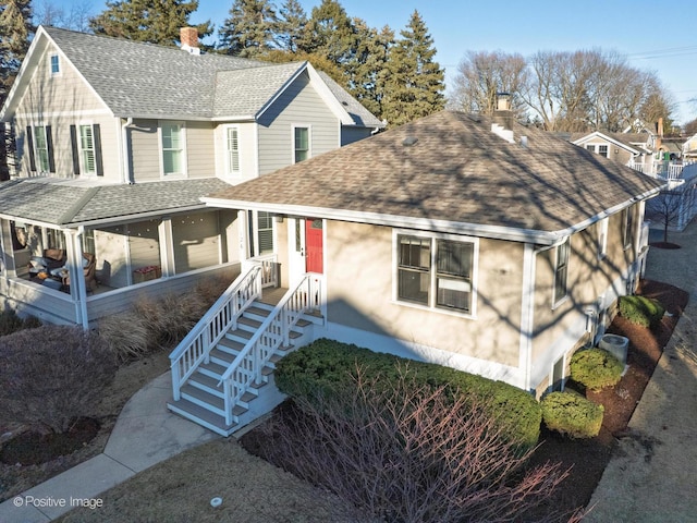 view of front of home with a chimney and a shingled roof