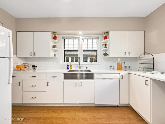 kitchen featuring a sink, white appliances, light countertops, and open shelves