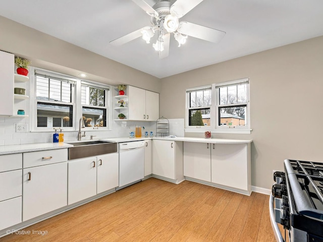 kitchen with a ceiling fan, open shelves, white dishwasher, a sink, and light countertops