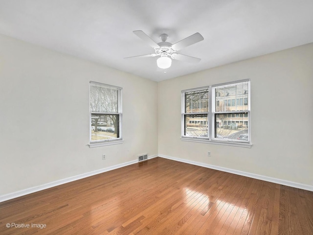 unfurnished room with visible vents, baseboards, ceiling fan, and hardwood / wood-style flooring