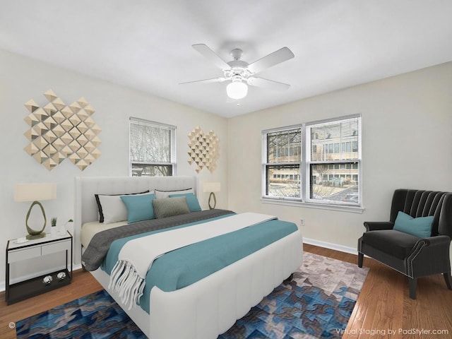 bedroom with a ceiling fan, wood finished floors, and baseboards