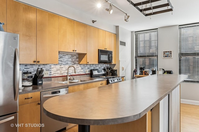 kitchen featuring tasteful backsplash, visible vents, light wood-style flooring, stainless steel appliances, and a sink