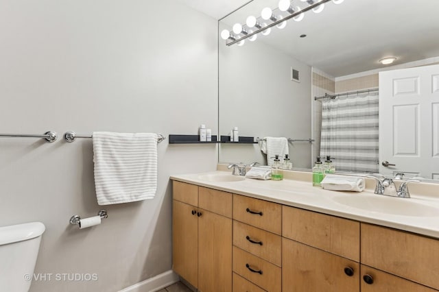 full bath with double vanity, visible vents, toilet, and a sink