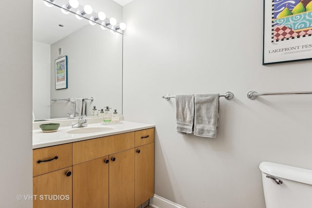 bathroom with vanity, toilet, and visible vents