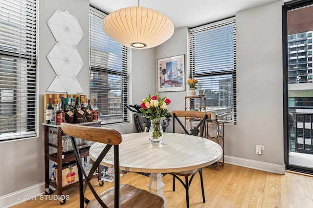 dining space with baseboards and hardwood / wood-style flooring