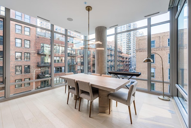 dining room featuring visible vents, wood finished floors, and expansive windows