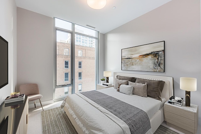 carpeted bedroom with a wall of windows and visible vents