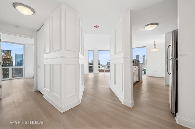 hall with a view of city and light wood-style flooring