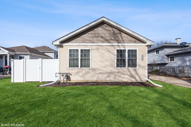 rear view of property with a lawn and fence