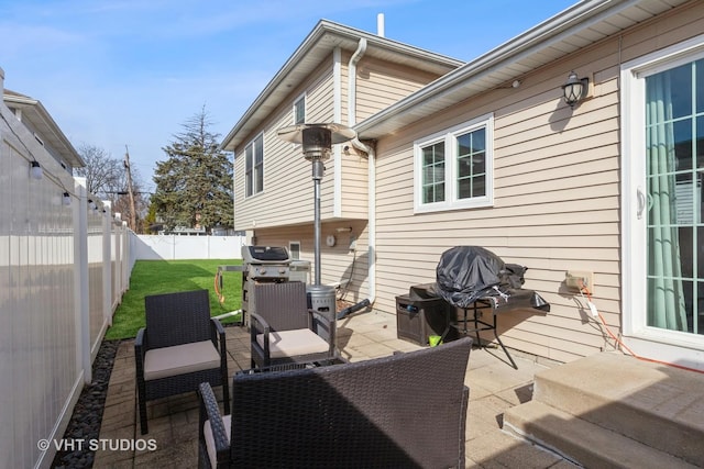 view of patio with grilling area, an outdoor hangout area, and a fenced backyard