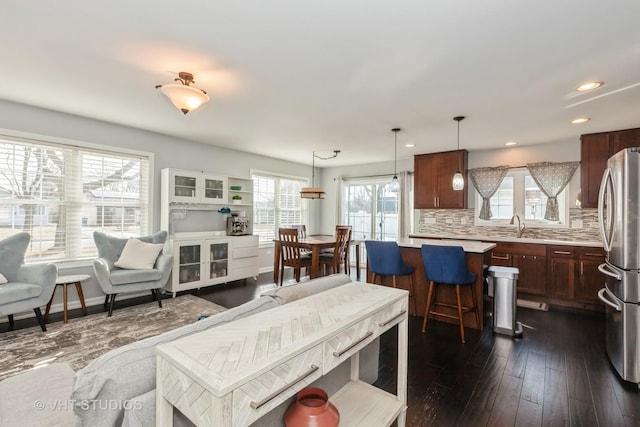 living area with recessed lighting, a healthy amount of sunlight, and dark wood-style flooring