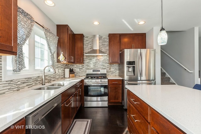 kitchen with backsplash, wall chimney exhaust hood, appliances with stainless steel finishes, and a sink