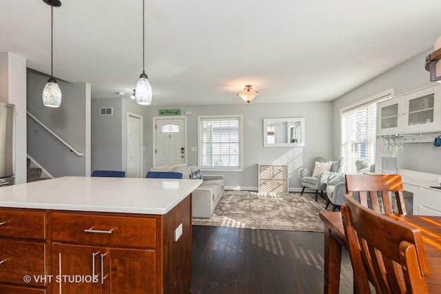 kitchen featuring visible vents, light countertops, dark wood-type flooring, and open floor plan