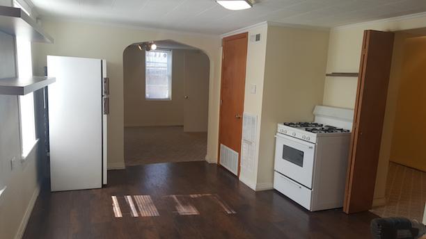 kitchen featuring white appliances, visible vents, dark wood finished floors, arched walkways, and crown molding