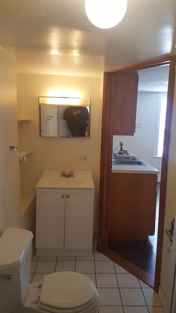 half bath featuring tile patterned flooring, toilet, and vanity