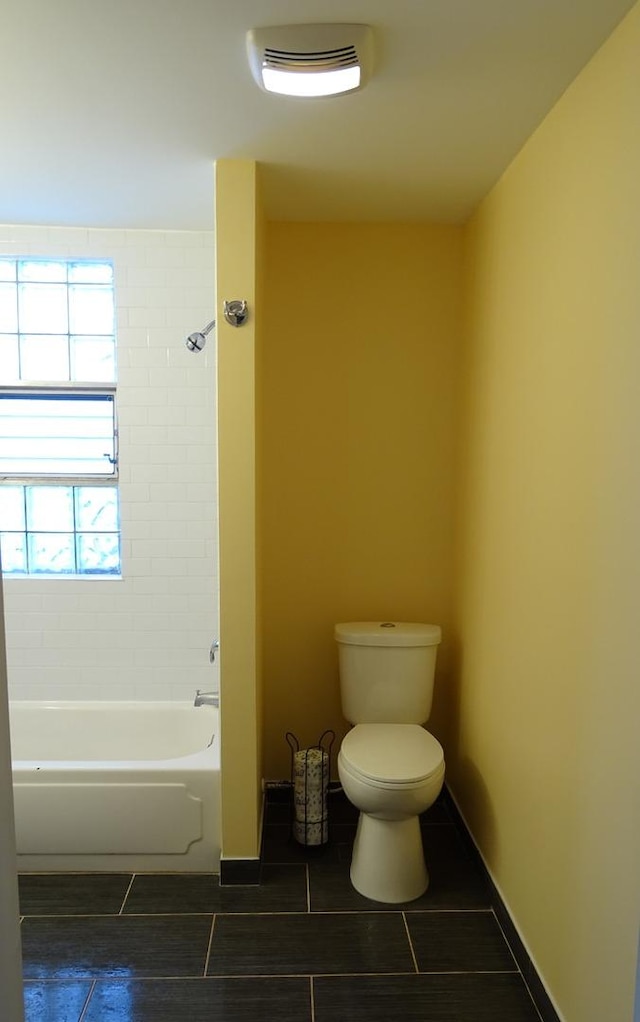 full bathroom with shower / bathing tub combination, toilet, baseboards, and tile patterned floors