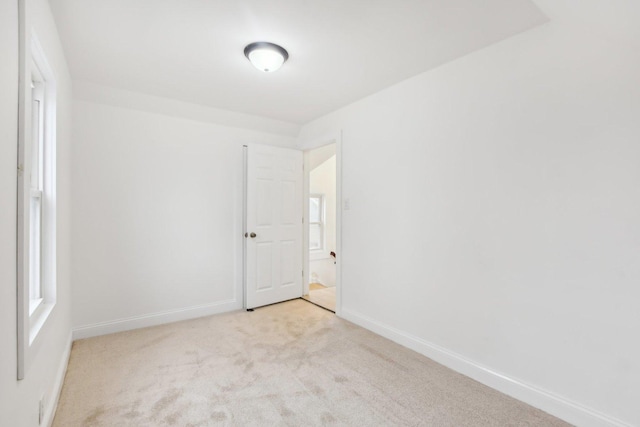 unfurnished room with baseboards and carpet flooring