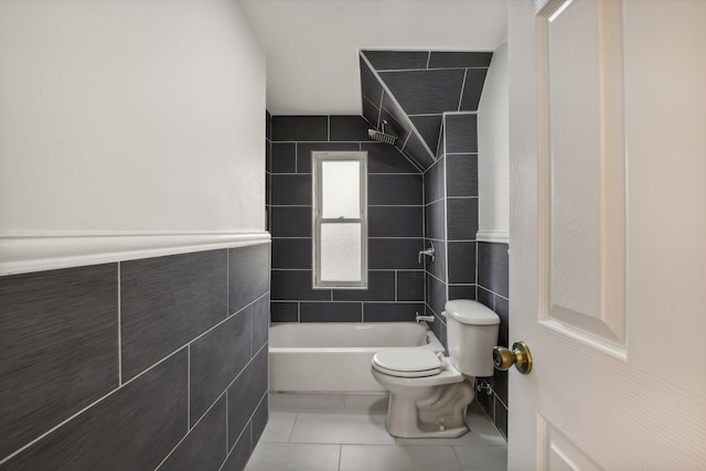 full bath with tile patterned floors, toilet, tile walls, and shower / washtub combination