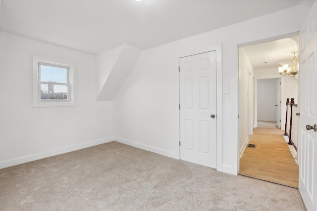 additional living space featuring visible vents, baseboards, an inviting chandelier, and carpet floors