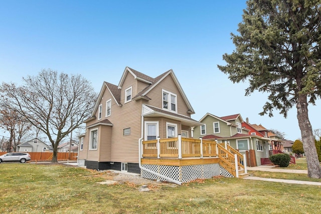 view of front of house with a deck, a front lawn, and fence