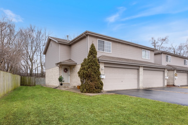 view of front of home featuring aphalt driveway, fence, an attached garage, a front yard, and brick siding