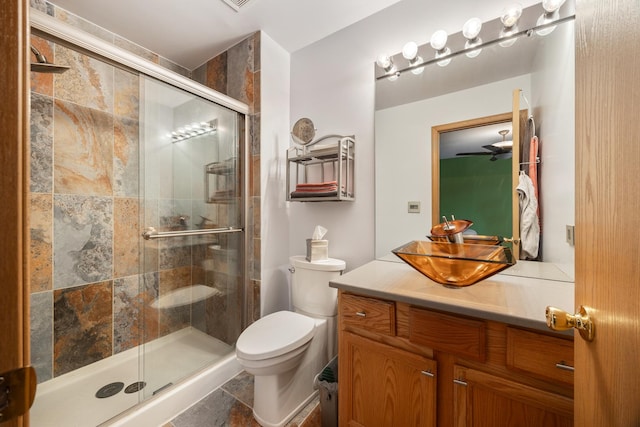 full bathroom featuring toilet, a stall shower, and vanity