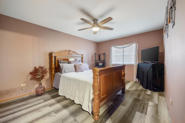 bedroom with wood finished floors, baseboards, and ceiling fan