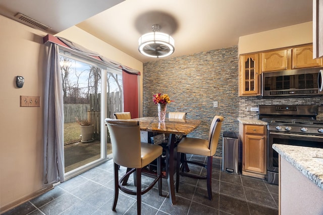 dining space with visible vents and dark tile patterned flooring