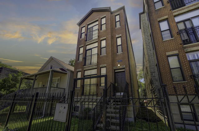 view of front of home featuring a fenced front yard and brick siding