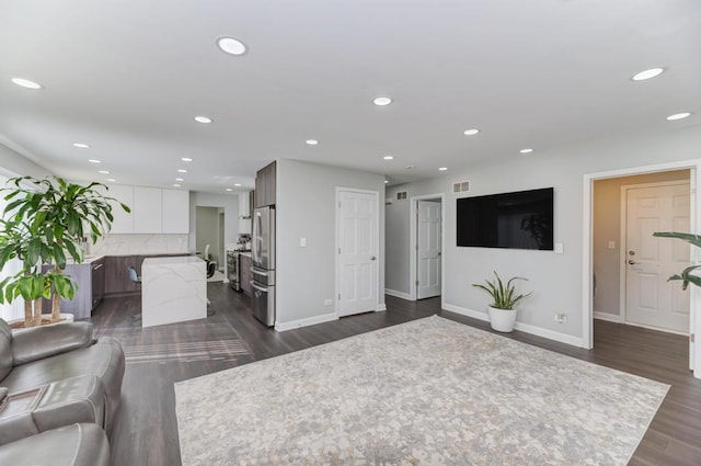 living area featuring recessed lighting, baseboards, and dark wood-type flooring