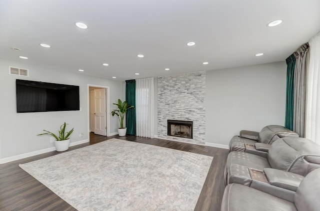 living room featuring recessed lighting, visible vents, dark wood finished floors, and a fireplace