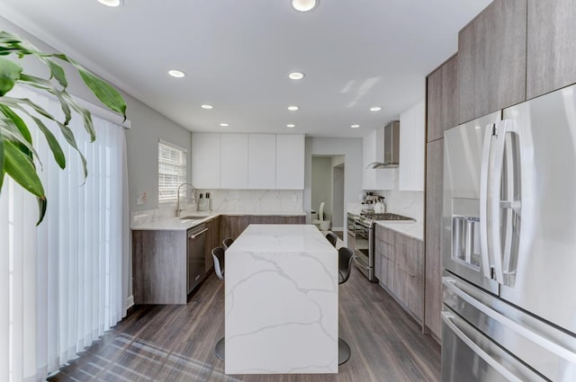 kitchen with decorative backsplash, wall chimney range hood, modern cabinets, and stainless steel appliances