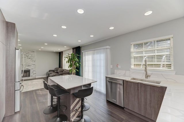 kitchen featuring dark wood finished floors, light stone counters, modern cabinets, and stainless steel appliances