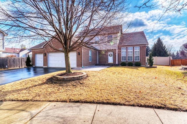 traditional-style house with aphalt driveway, brick siding, a front yard, and fence