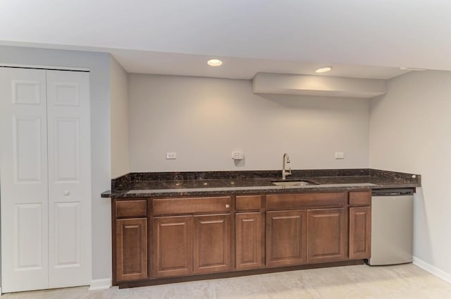 kitchen featuring a sink, stainless steel dishwasher, recessed lighting, dark stone counters, and baseboards