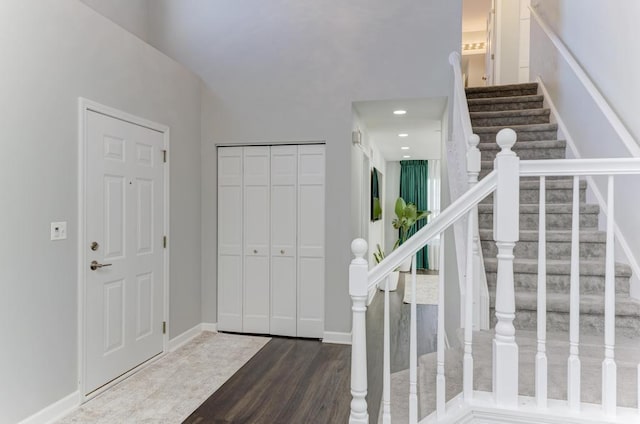 foyer with stairway, baseboards, and wood finished floors