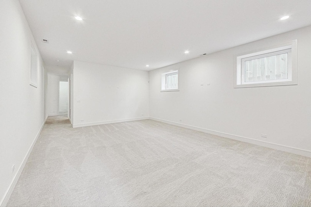 empty room featuring recessed lighting, baseboards, and light carpet