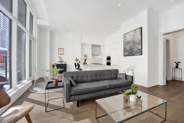 living room featuring recessed lighting, baseboards, wood finished floors, and ornamental molding