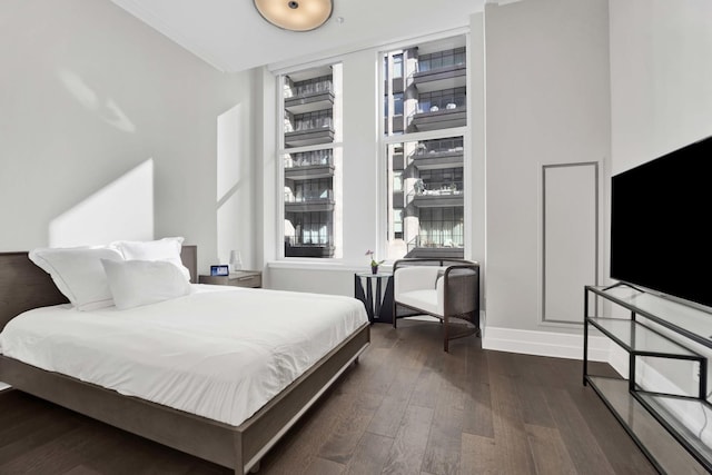 bedroom with dark wood-type flooring and baseboards