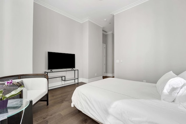 bedroom featuring crown molding, baseboards, and wood finished floors