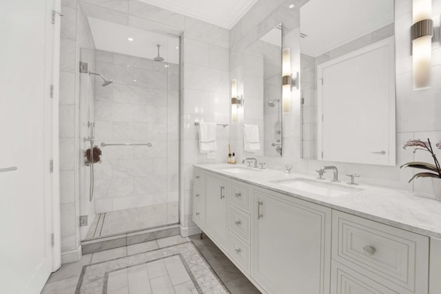 bathroom with tile walls, a stall shower, and a sink