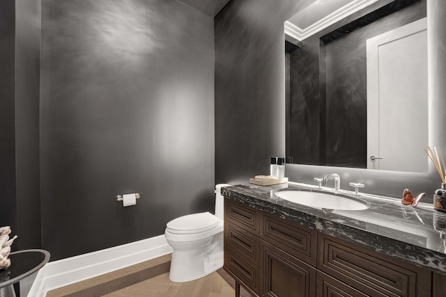 half bath featuring toilet, vanity, baseboards, and wood finished floors